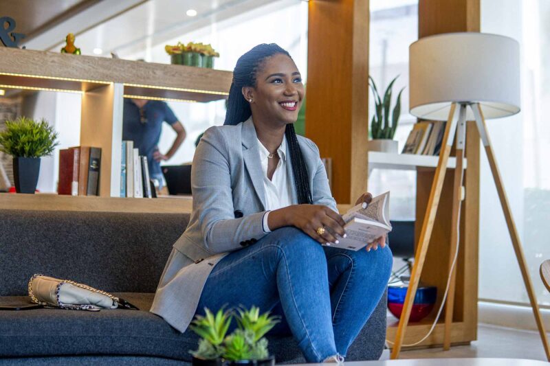 a woman sits on a couch reading a book