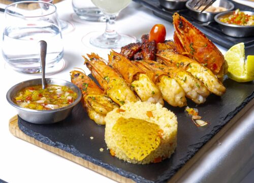 a plate of food with shrimp and rice on a table