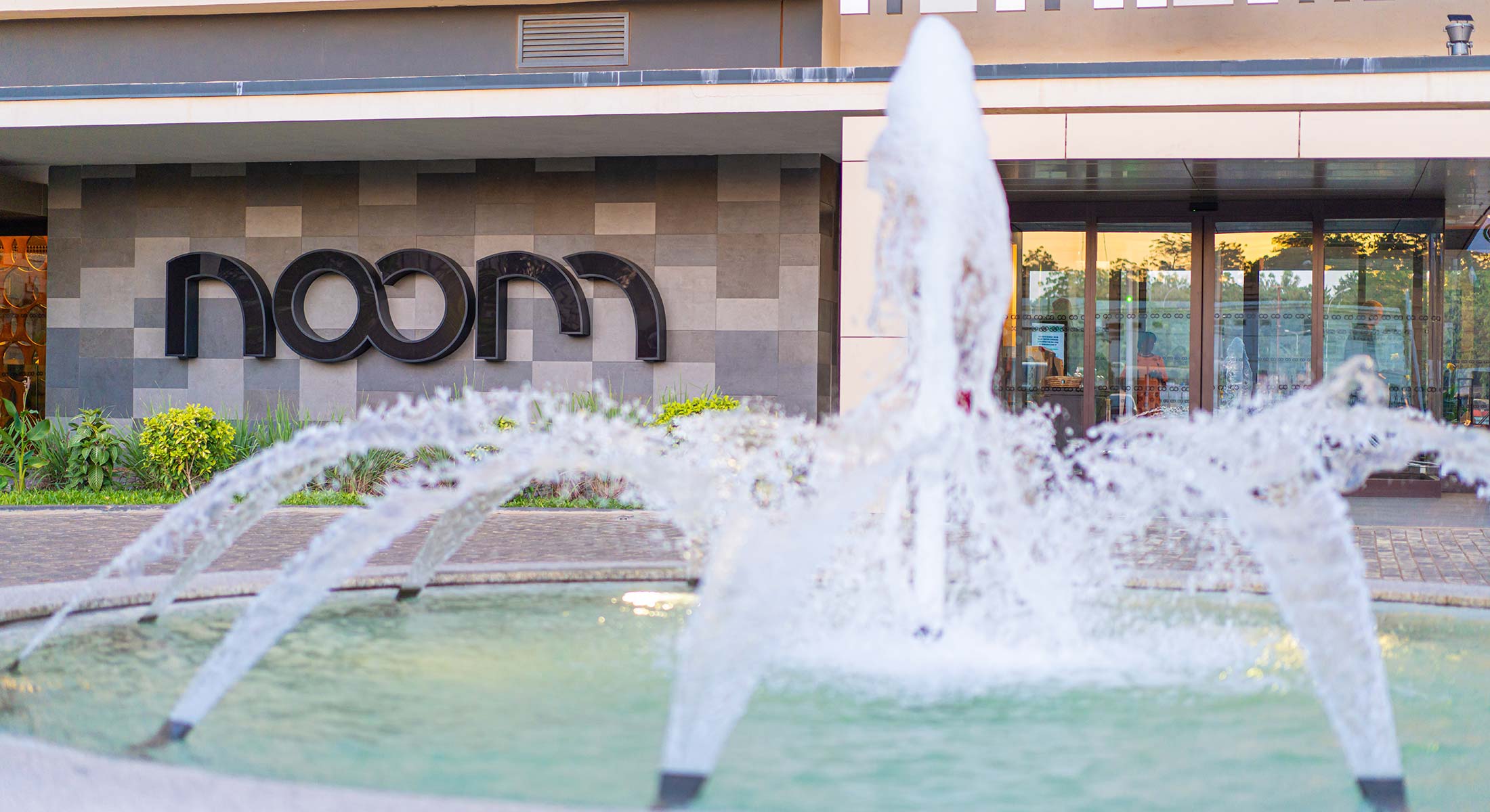 a fountain in front of a building that says noom