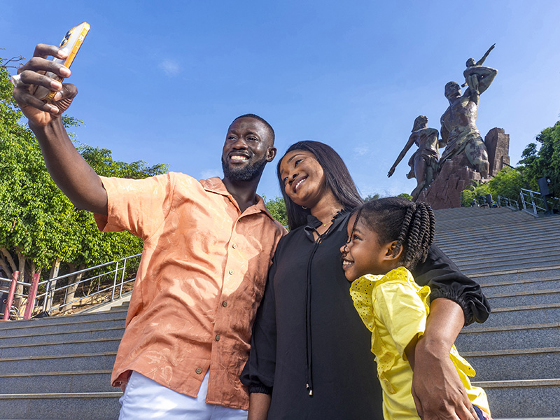 a family taking a selfie in front of a statue