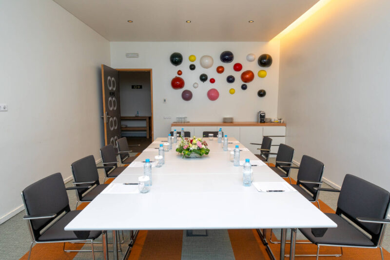 une salle de conférence avec une table blanche et des chaises