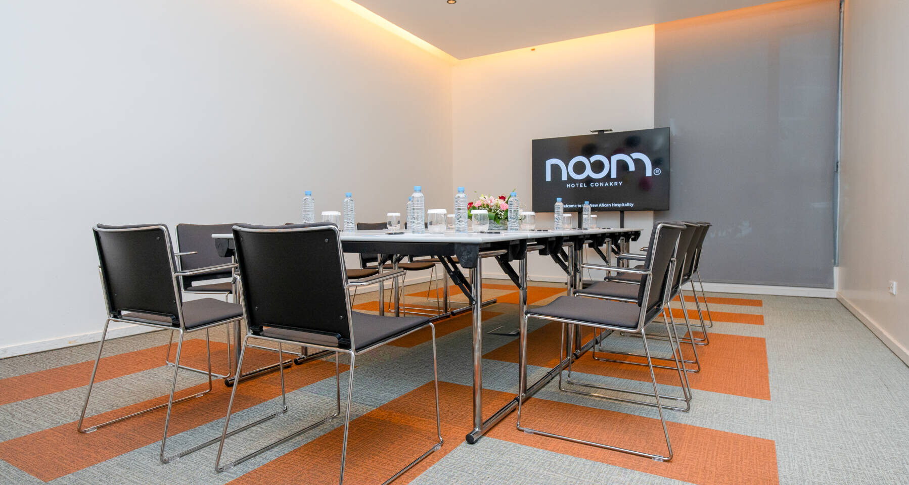 une salle de conférence avec une table blanche et des chaises