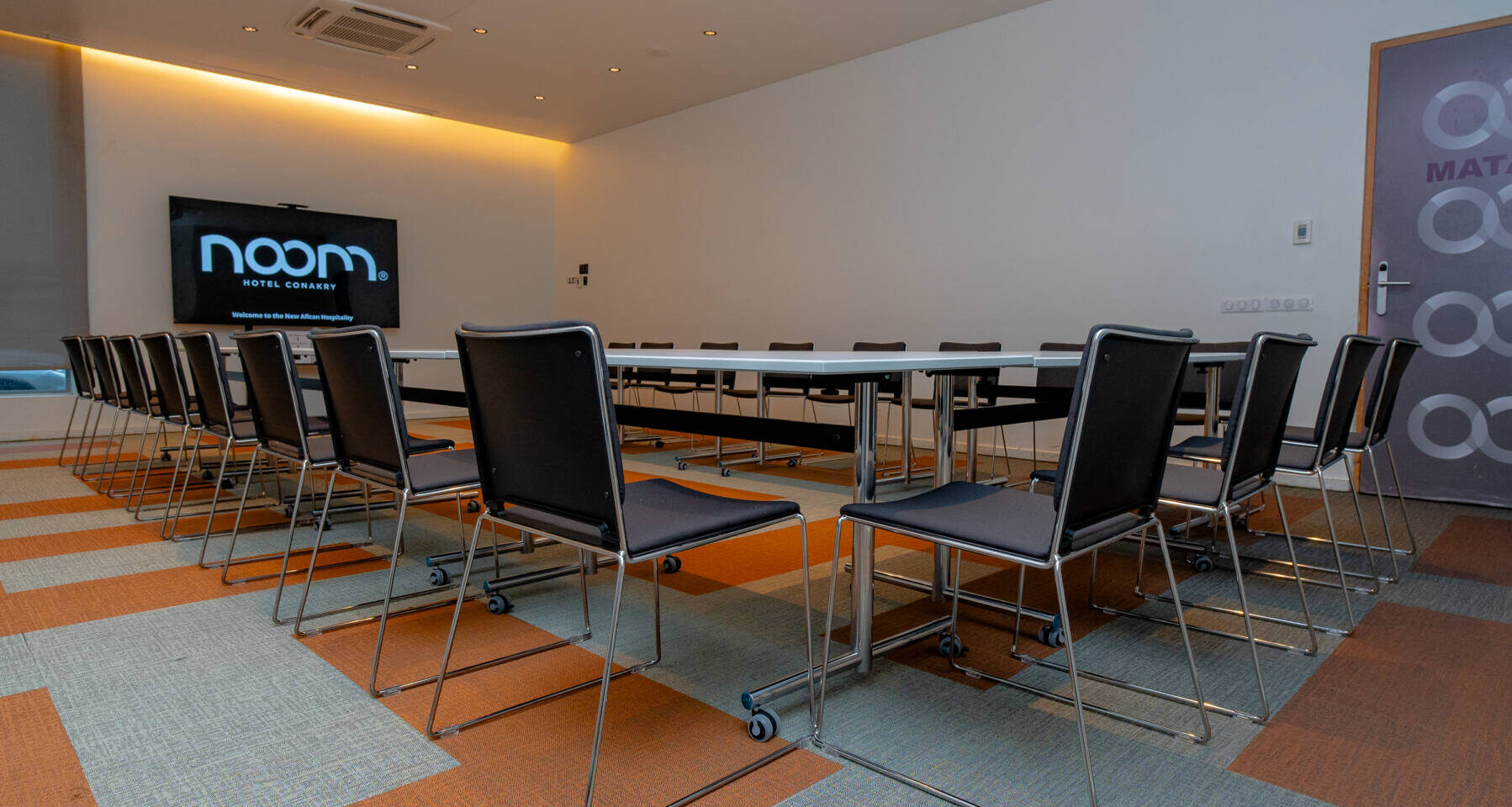 une salle de conférence avec une table blanche et des chaises
