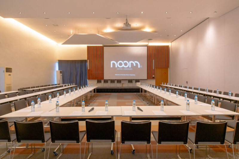 a conference room with chairs and white tables