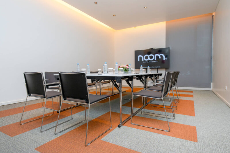 une salle de conférence avec une table blanche et des chaises