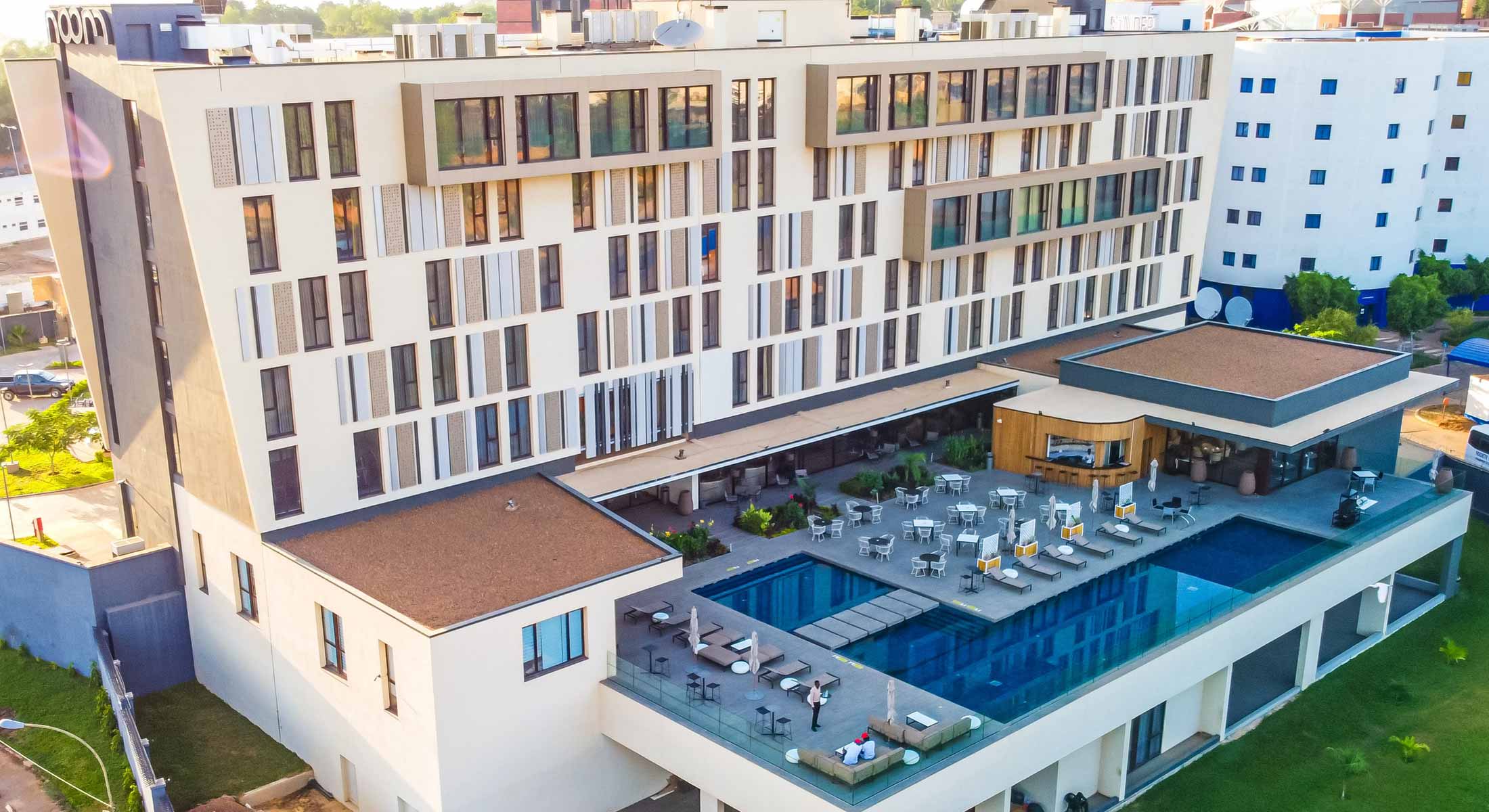 an aerial view of a hotel with a large swimming pool