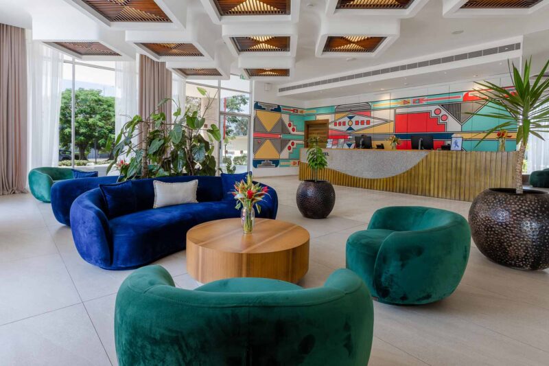 un salon avec un canapé bleu et des chaises vertes