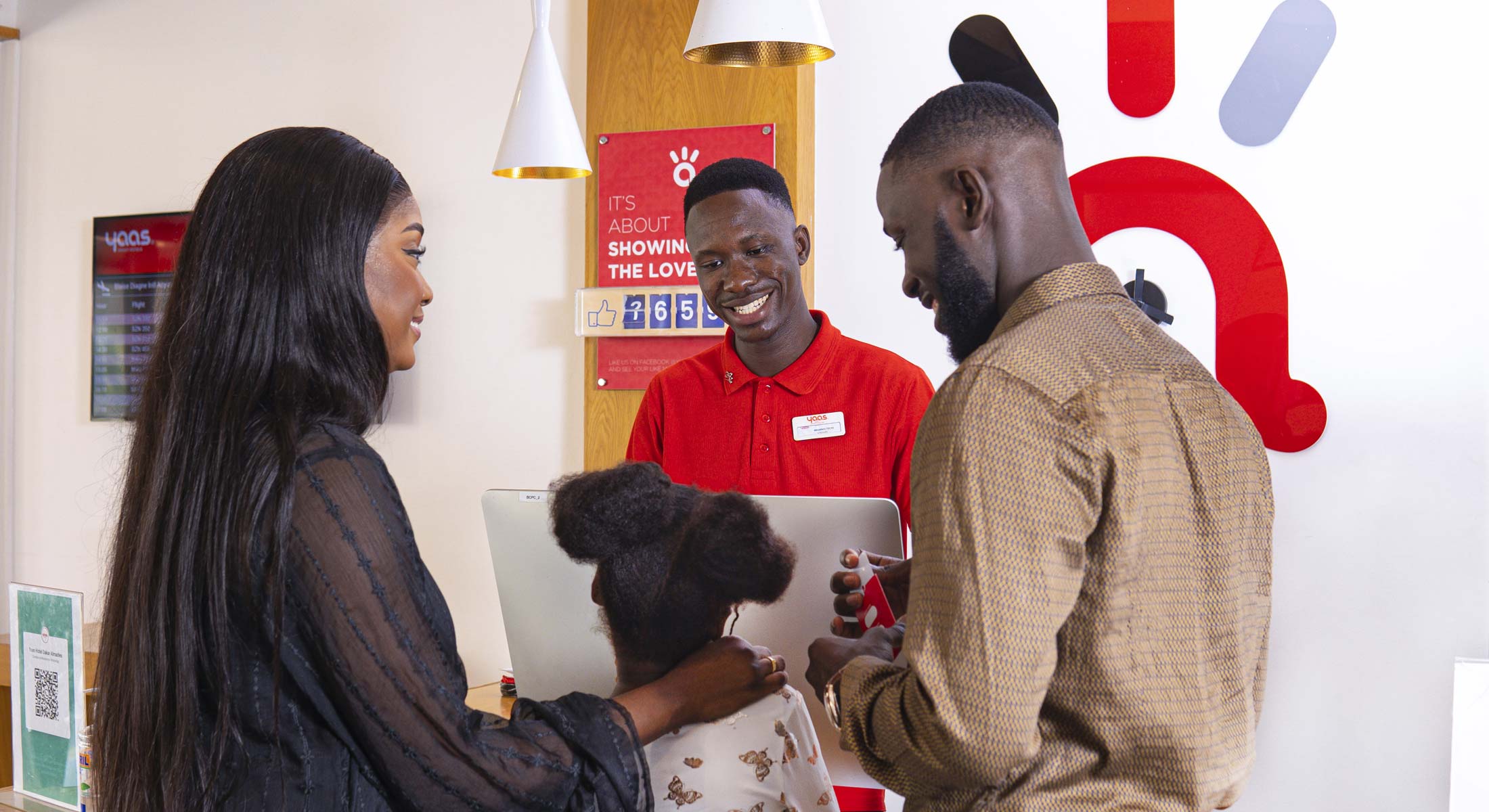 A man, a woman and a child stand in front of the reception of a YAAS hotel