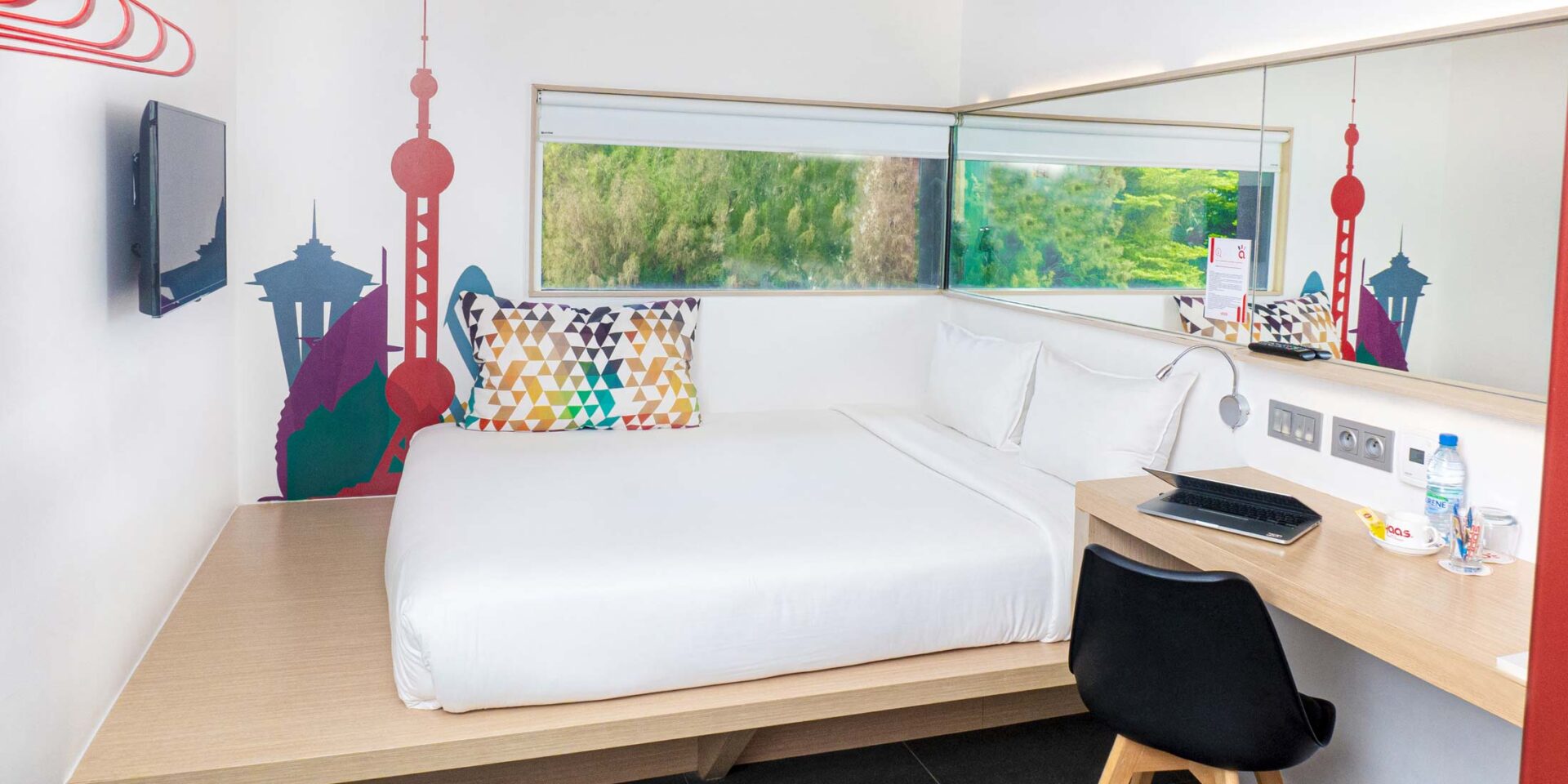 a small hotel room with a bed and a desk