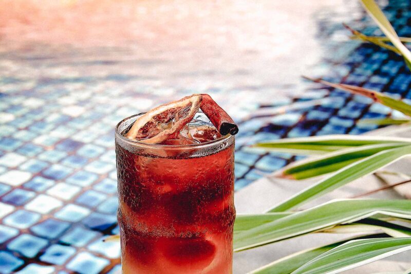 un verre de boisson rouge avec une tranche d'orange sur le dessus