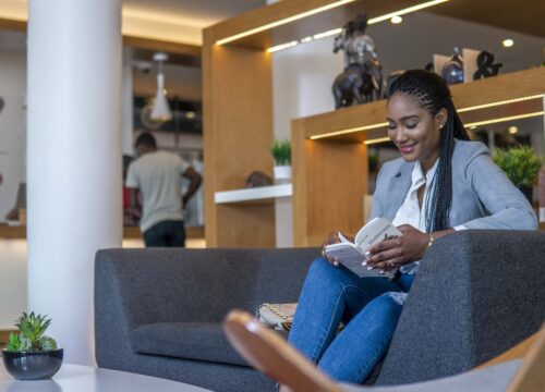 a woman sits on a couch reading a book