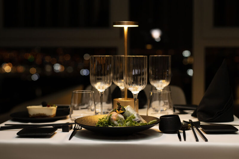 une table avec une assiette de nourriture et des verres de vin
