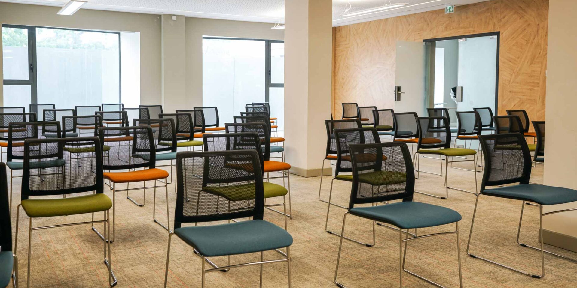 une rangée de chaises colorées dans une salle de conférence