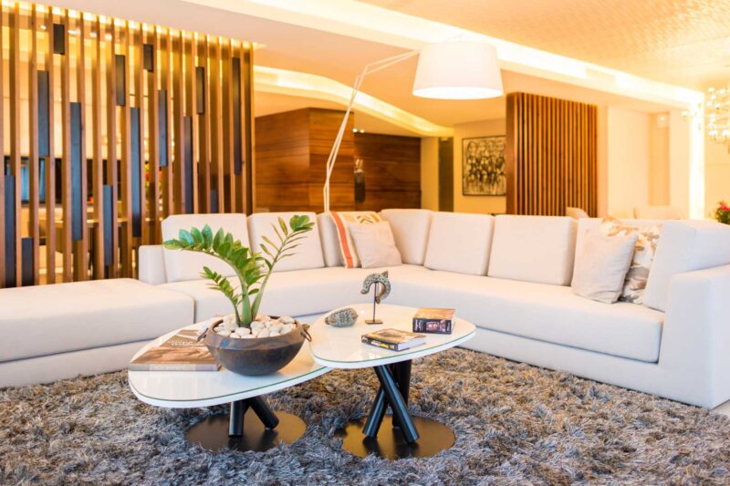 a living room with a white sectional couch and two tables