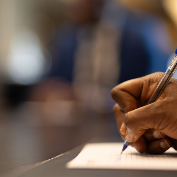 une personne écrit avec un stylo bleu sur un morceau de papier une personne écrit avec un stylo bleu sur un morceau de papier