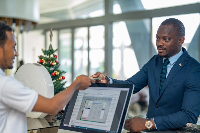 a man in a suit is giving a credit card to another man