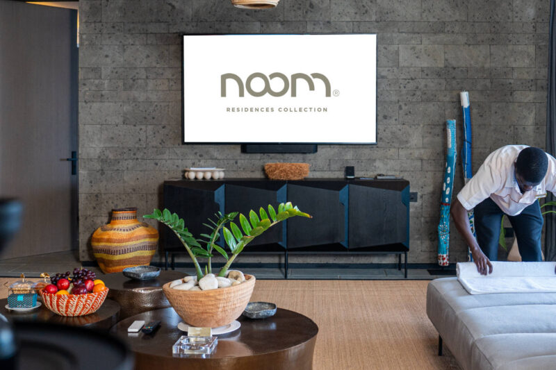 Salon avec télévision, mobilier et un membre du personnel.