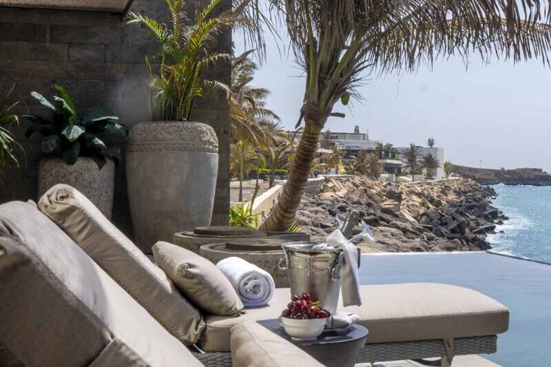 Un espace détente luxueux au bord de la piscine avec vue sur l'océan.