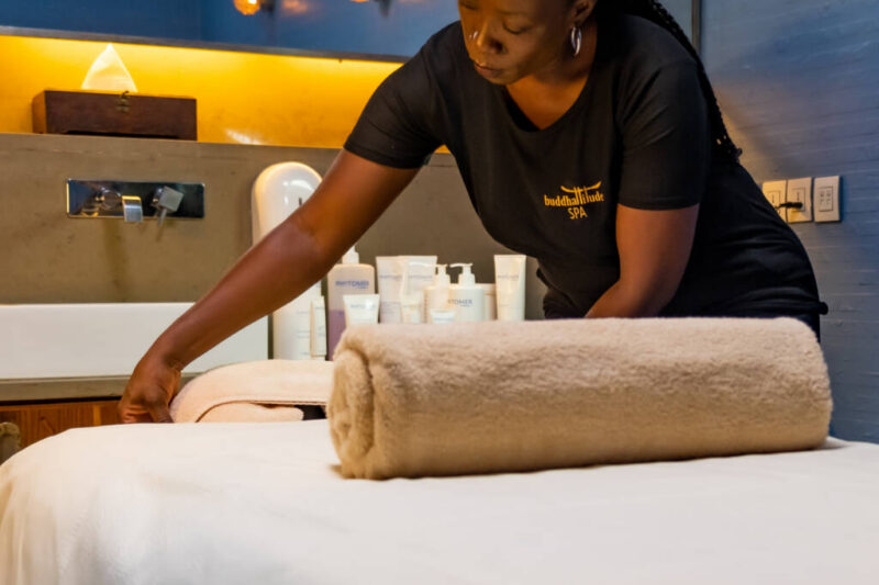 Un employé du spa prépare une table de massage.