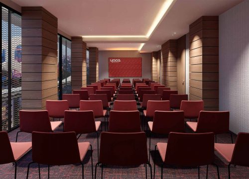 Conference room with rows of red chairs facing a presentation screen.