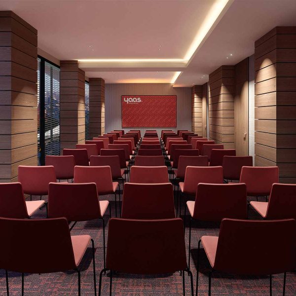 Conference room with rows of red chairs facing a presentation screen.