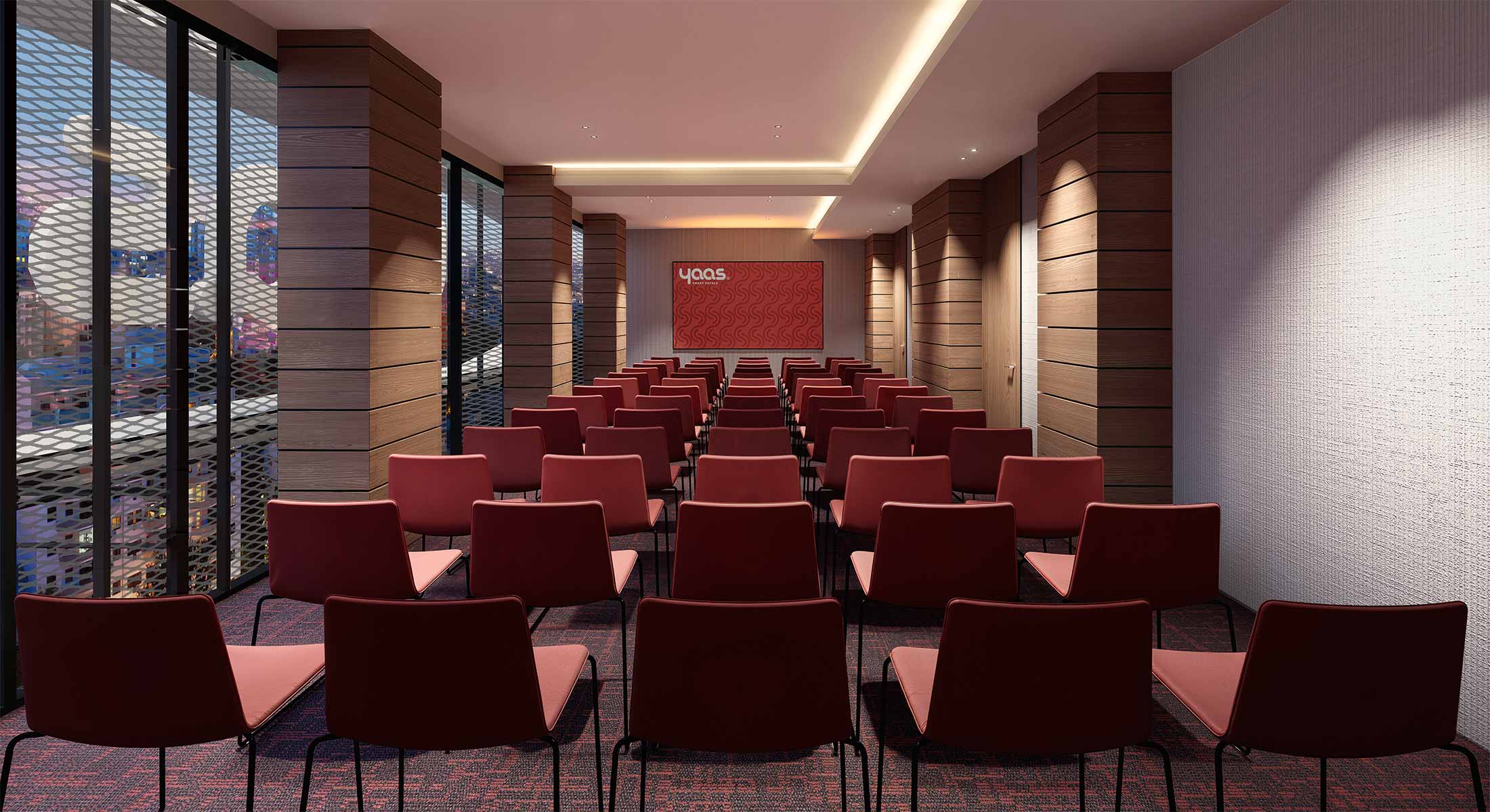 Conference room with rows of red chairs facing a presentation screen.