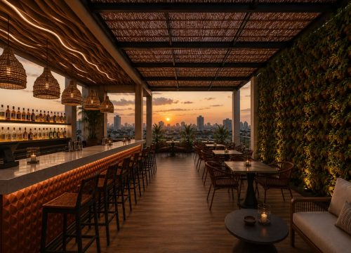 Modern rooftop bar and terrace overlooking a city skyline at sunset.