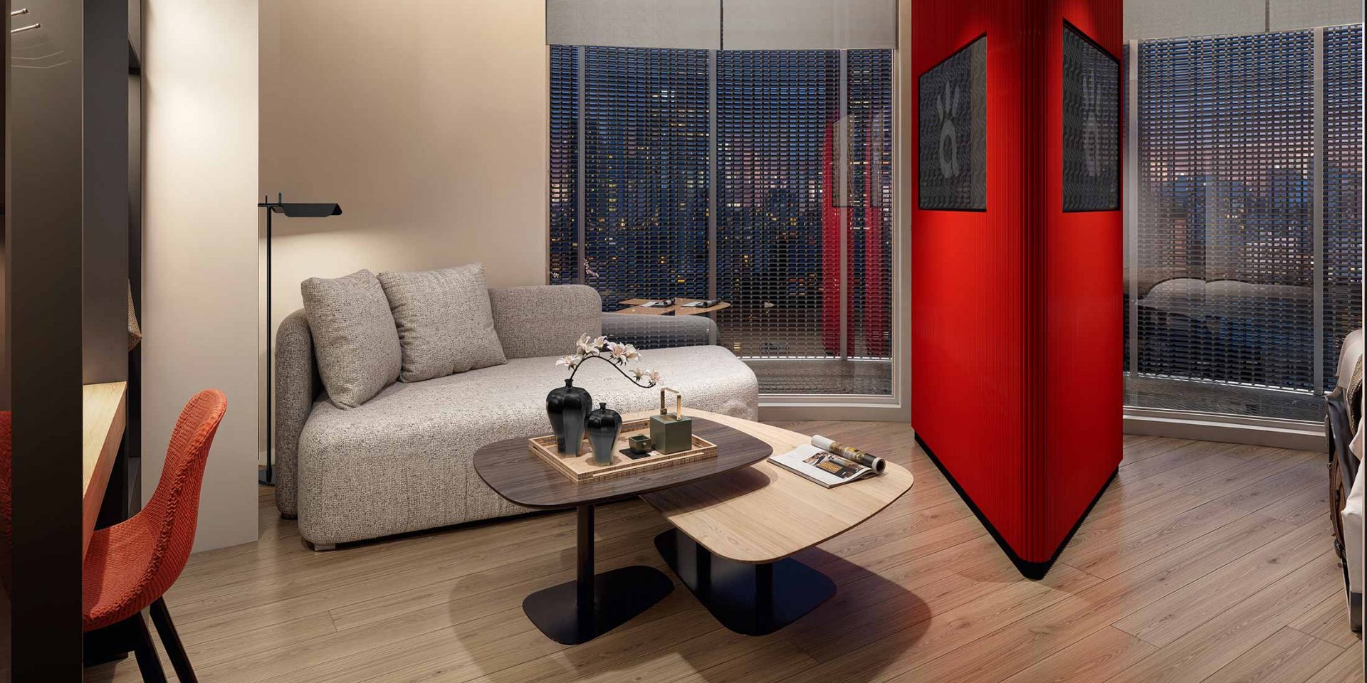 Modern living room with a gray sofa, coffee tables, and a vibrant red partition wall.