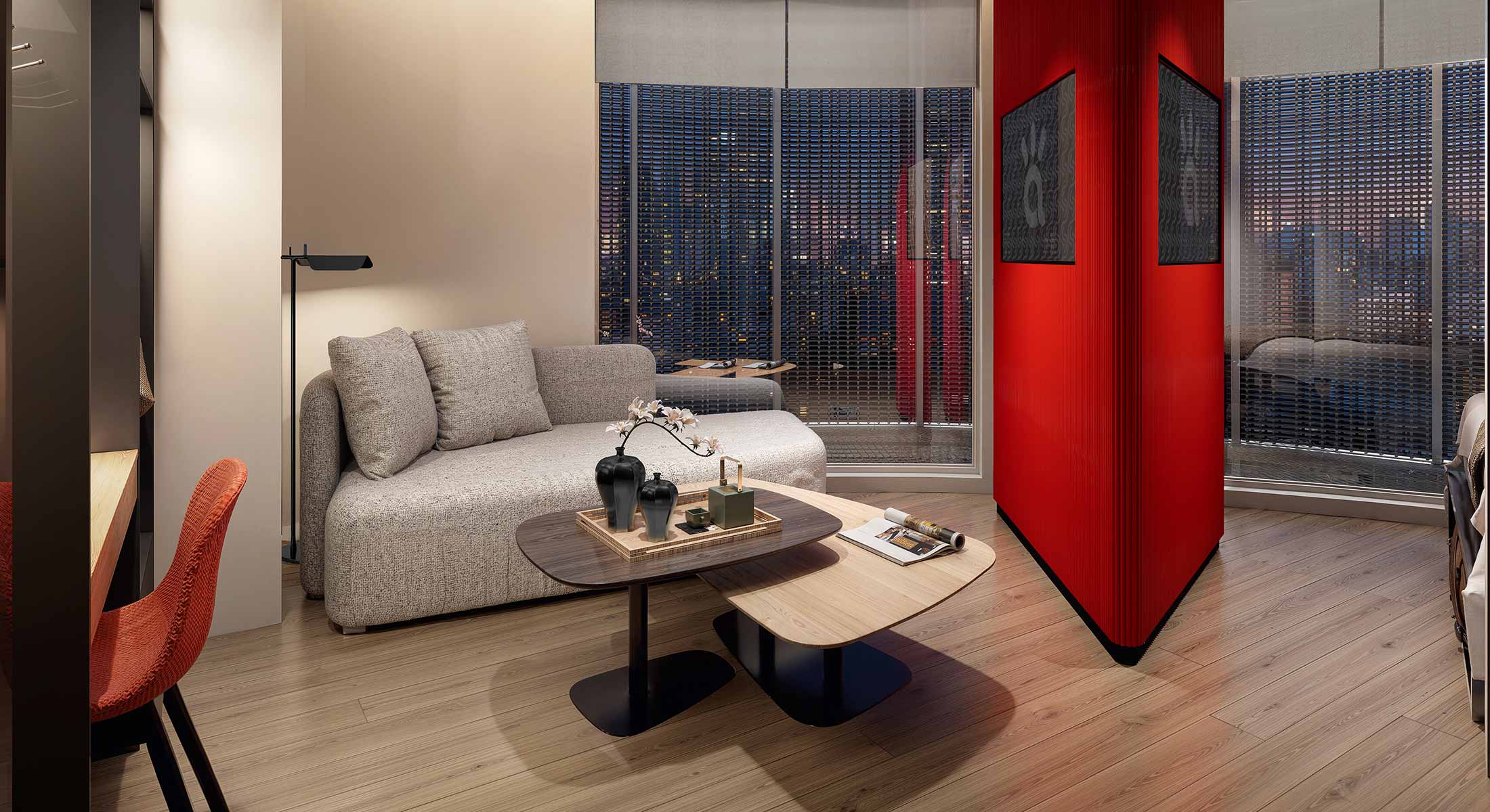 Modern living room with a gray sofa, coffee tables, and a vibrant red partition wall.