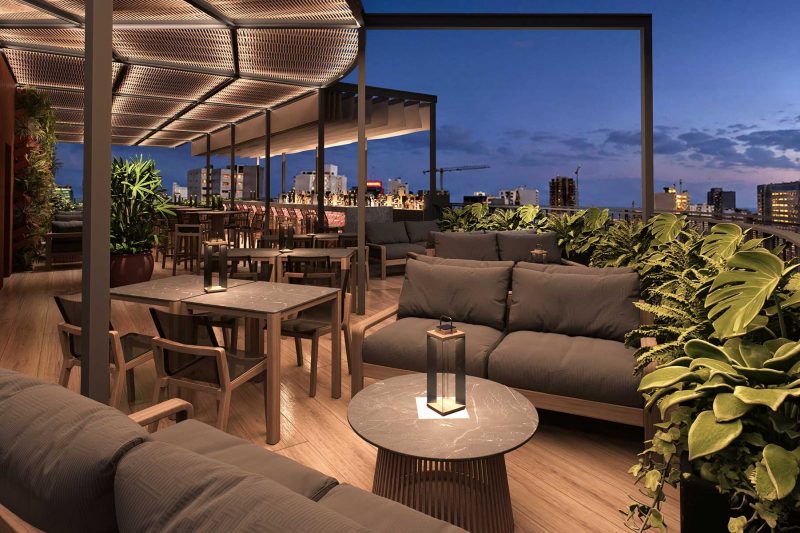 Modern rooftop terrace lounge with seating and city views at dusk.