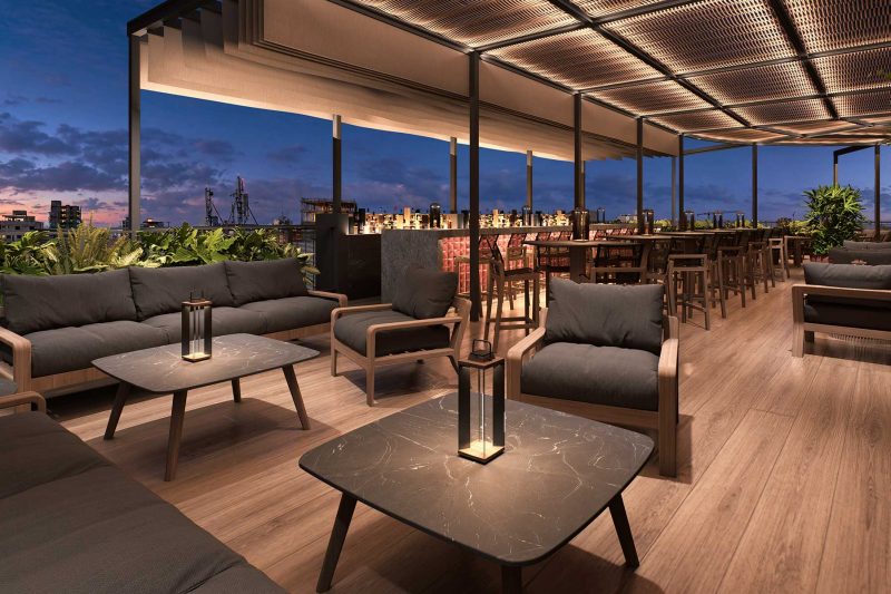Modern rooftop lounge with outdoor seating and a bar at dusk.