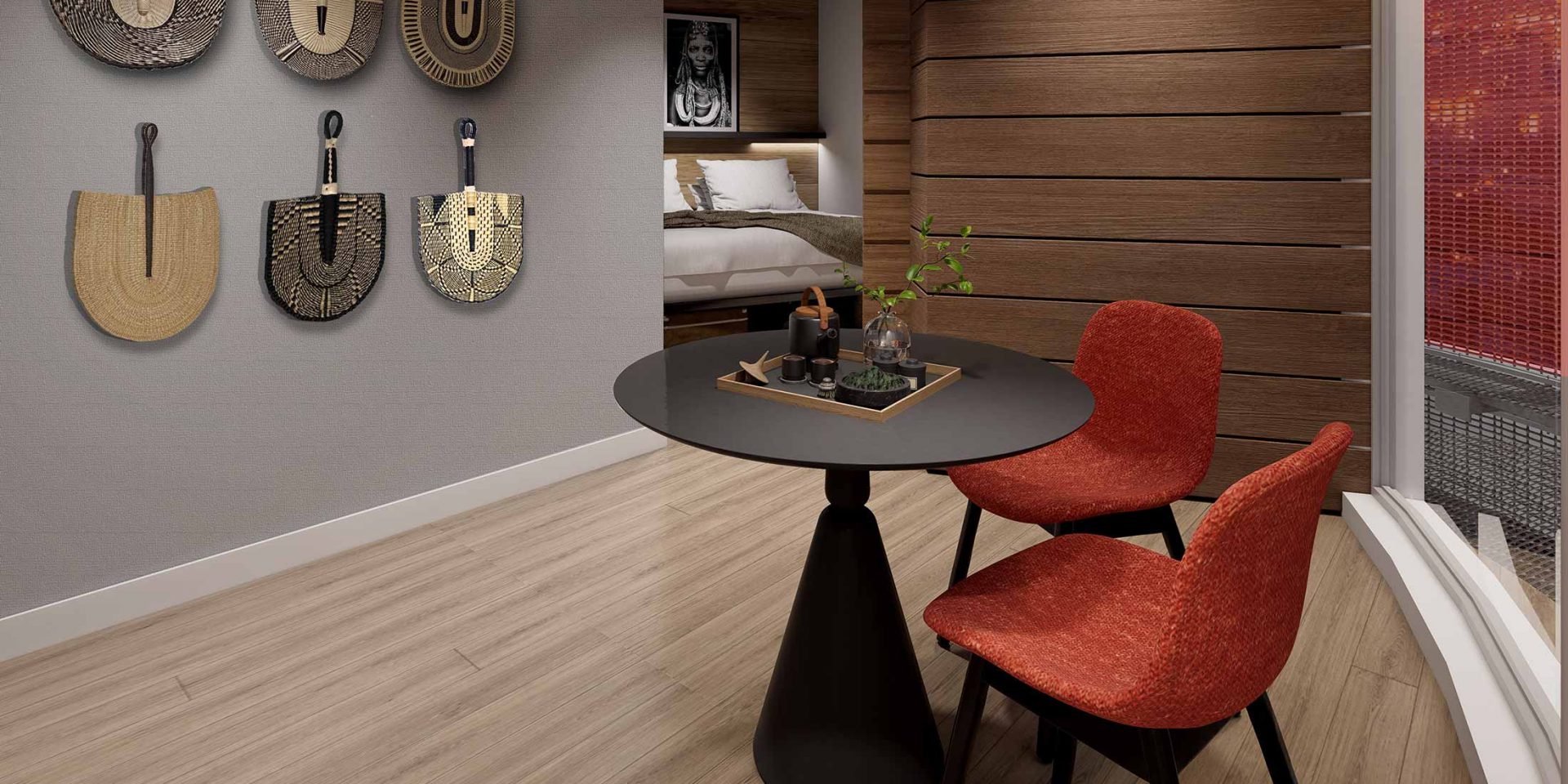 Round black table with two red chairs in a modern room with wall decor.