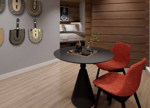 Round black table with two red chairs in a modern room with wall decor.