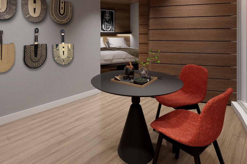 Round black table with two red chairs in a modern room with wall decor.