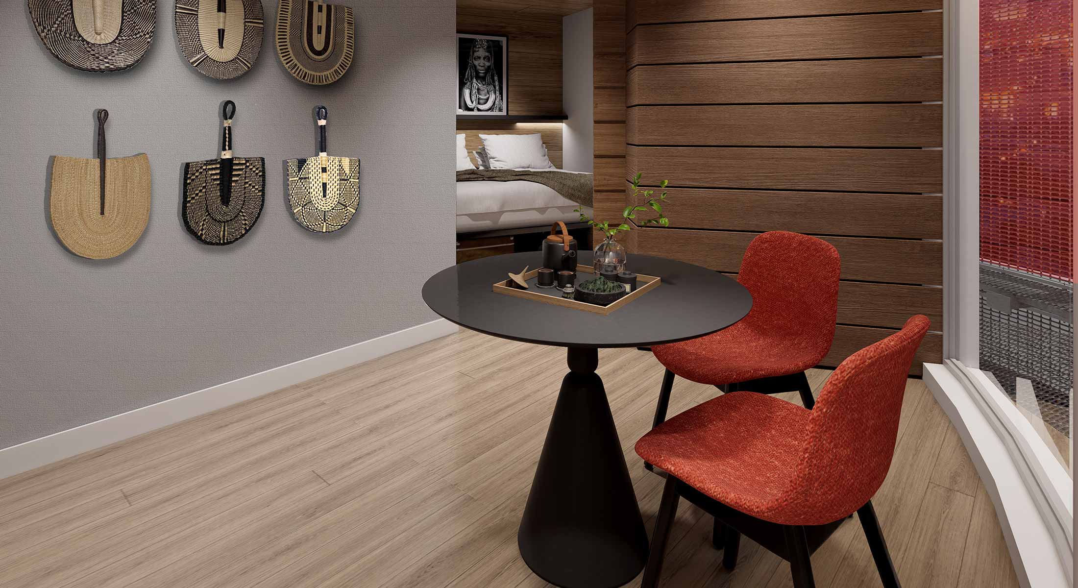 Round black table with two red chairs in a modern room with wall decor.