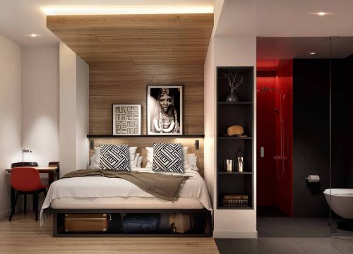 Modern hotel room with a wood-paneled bed alcove and an adjoining bathroom.