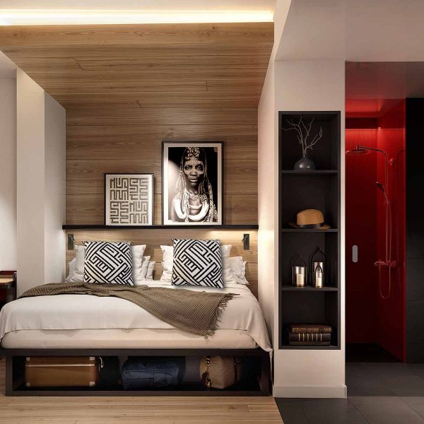 Modern hotel room with a wood-paneled bed alcove and an adjoining bathroom.