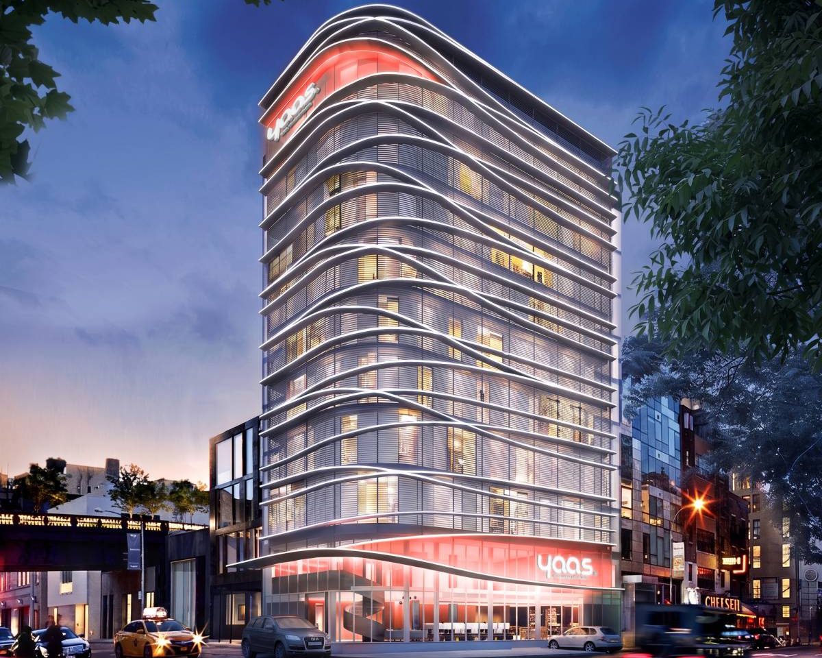 Hotel moderne de plusieurs étages, doté d'une façade ondulée et illuminée, situé dans une rue de la ville la nuit.